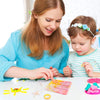 A woman is helping a child make colorful silicone mold game pieces for a tic-tac-toe game.