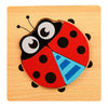 A wooden puzzle set depicting a ladybug with black and red sections on a light wood background.