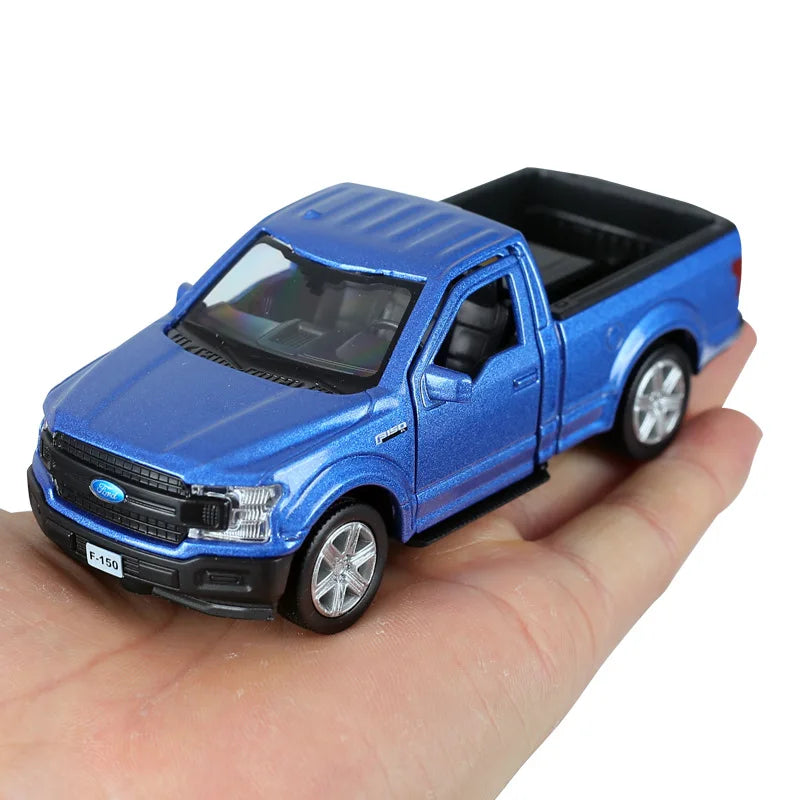 A blue Ford F-150 SVT Raptor 1:36 diecast model truck being held in a hand.