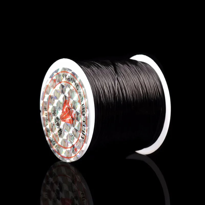 A spool of black elastic beading cord for stretch bracelets and necklaces is shown against a black background.