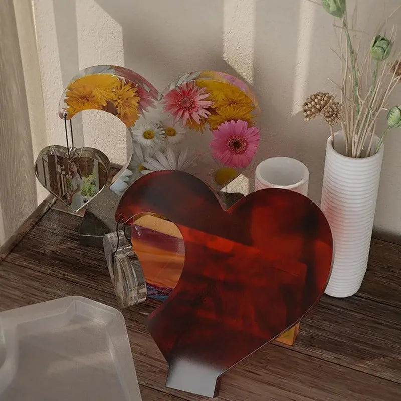 A collection of heart-shaped resin molds and photo frames in various colors and designs for DIY crafts.