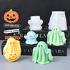 A collection of silicone ghost molds in white and green, alongside a carved pumpkin, displayed on a dark box.