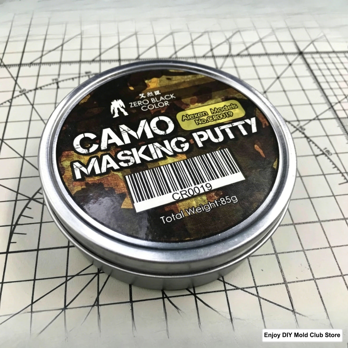 A tin of Camo Masking Putty for model painting placed on a grid background.