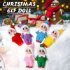 A collection of adorable plush Christmas elf dolls in various colors and outfits resting on a snowy surface.