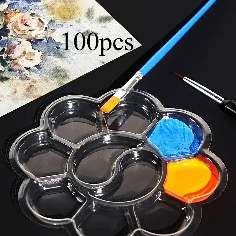 A clear, flower-shaped disposable paint palette with several colorful paint tubes and a brush is shown on a dark surface.