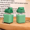 A pair of green duck and frog fidget clicker keychains resting on a wooden surface.