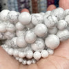 A handful of round white and gray marbled gemstone beads for jewelry making