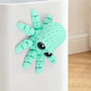 A light green 3D printed articulated octopus fridge magnet with textured skin and black eyes.