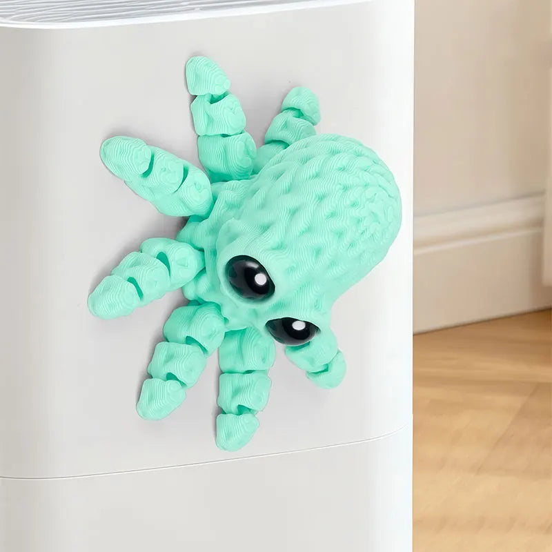 A light green 3D printed articulated octopus fridge magnet with textured skin and black eyes.