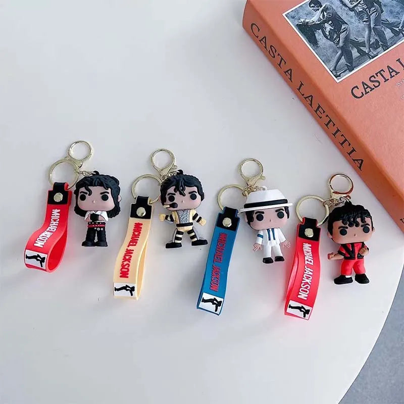 Keychain featuring a miniature Michael Jackson figure attached to a metal buckle and a leather tag.
