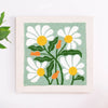 A square punch needle embroidery featuring white and yellow daisies on a pale green background.