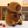 A brown plush capybara stuffed animal wearing a brown knit scarf sitting on a white surface.