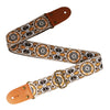 An embroidered guitar strap featuring floral patterns on a tan fabric with brown leather ends.