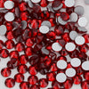 A close-up view of red and silver glass crystal flatback rhinestones scattered on a white background.