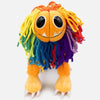 A colorful lion stuffed animal plush toy with long, multicolored yarn mane and orange paws.