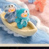 A collection of soft, fluffy teddy bears in various pastel colors and textures resting on a light wooden boat.
