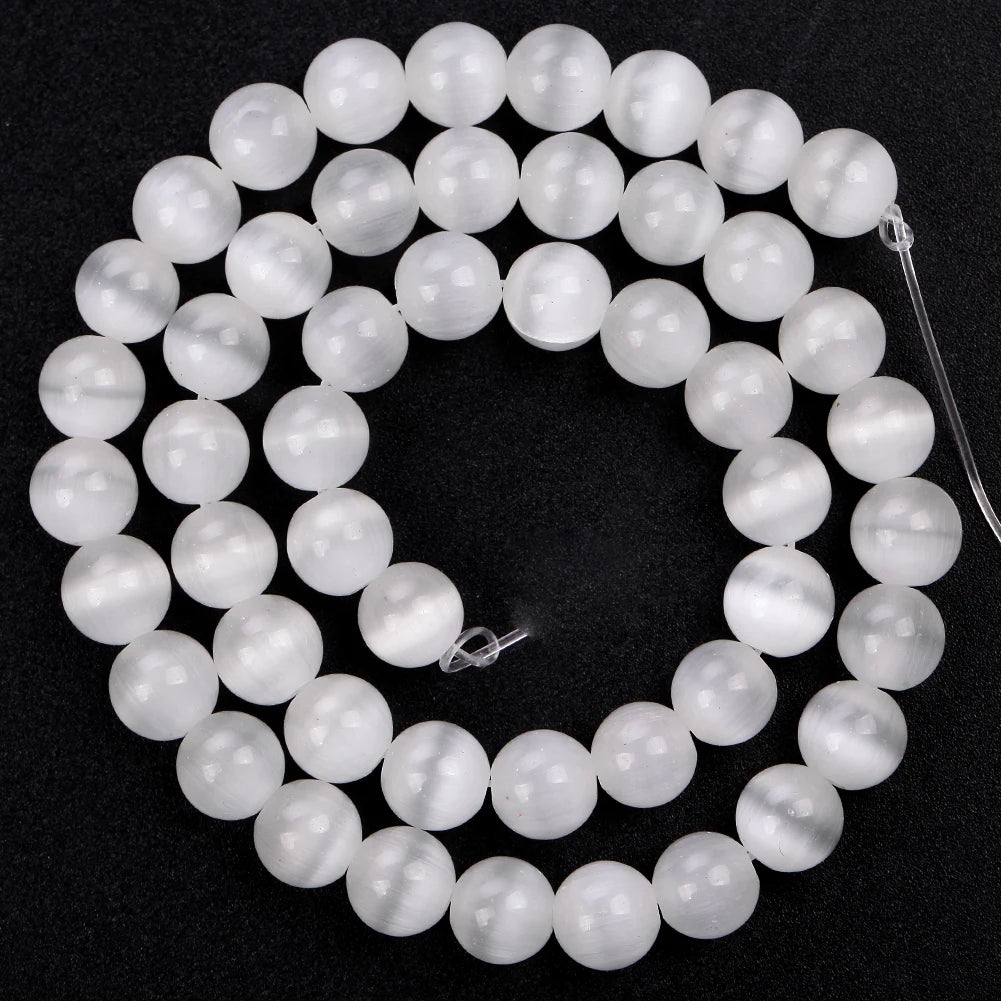 A circular arrangement of smooth, translucent white and light blue natural sea sediment jasper and turquoise beads for jewelr
