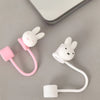 A white Miffy straw topper with a pink loop and a white stopper is shown on a gray surface.