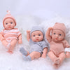 A set of realistic soft vinyl reborn baby dolls dressed in striped clothing and knitted hats, lying on white fluffy material.