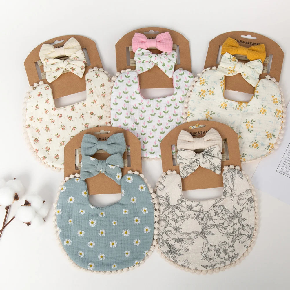 A set of three baby flower bibs and headbands in various floral patterns and pink, yellow, and gray colors.