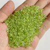 A handful of bright lime green natural tumbled stone chips for jewelry making and home decor
