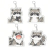 A set of four cute raccoon acrylic keychains featuring different facial expressions.