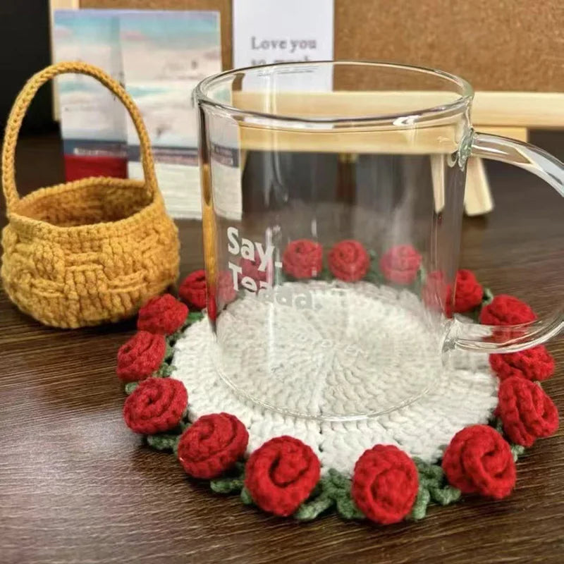 Hand-crocheted red and green lily of the valley coasters displayed around a glass mug.