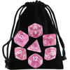 A set of transparent pink polyhedral dice inside a black drawstring bag.