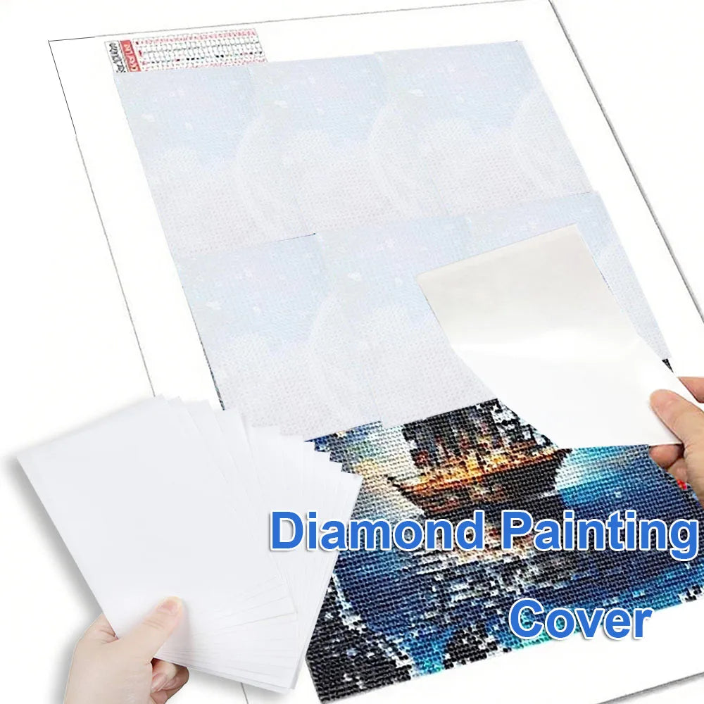 A hand holds a sheet of diamond painting cover paper featuring a blue and black seascape.