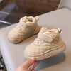 A pair of beige toddler winter snow boots with quilted fabric and soft sherpa lining being held by a hand.