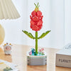 A pink rose flower building block bouquet set with green stems and leaves displayed on a wooden table.