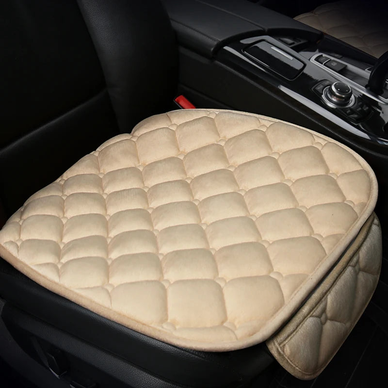 A beige quilted car seat cushion set with a matching cover resting on a black car seat.