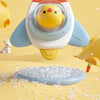 A yellow and white baby bath toy with a suction cup spinner is shown above scattered clear plastic beads on a yellow surface.