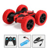 A red RC car with large tires and black chassis is shown alongside its remote control and battery.