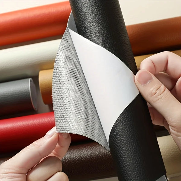 A hand is peeling a gray self-adhesive leather repair patch from a black rolled material.