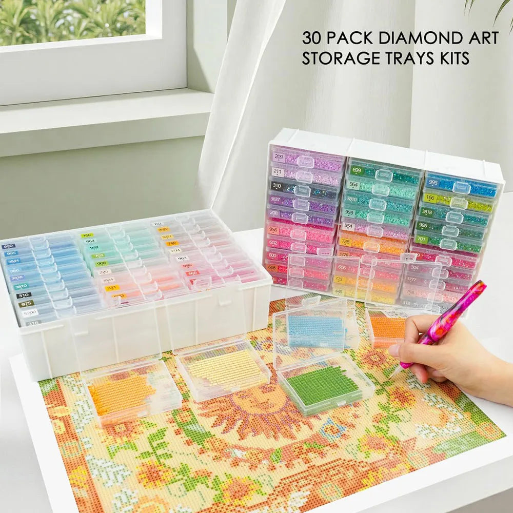 A collection of 30 diamond art storage trays and kits arranged in a white box on a colorful painting mat.