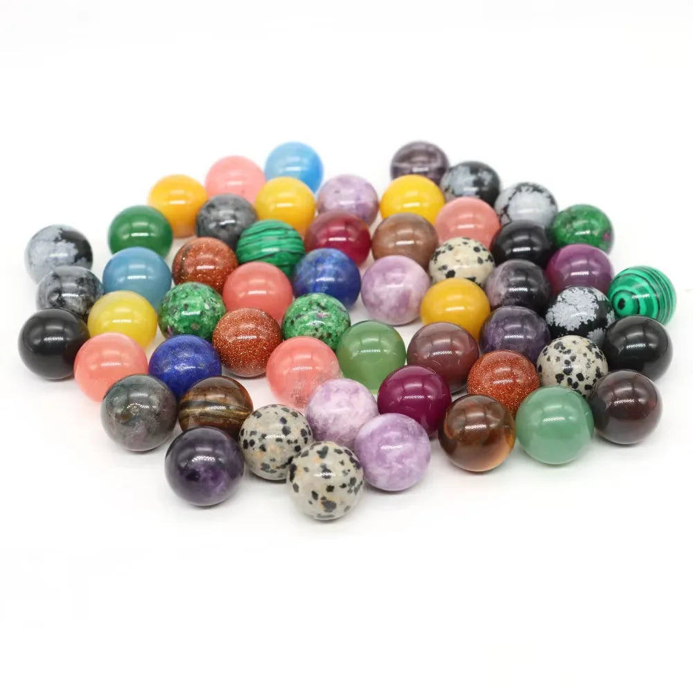 A collection of polished crystal spheres in various shades of purple, pink, green, and yellow.