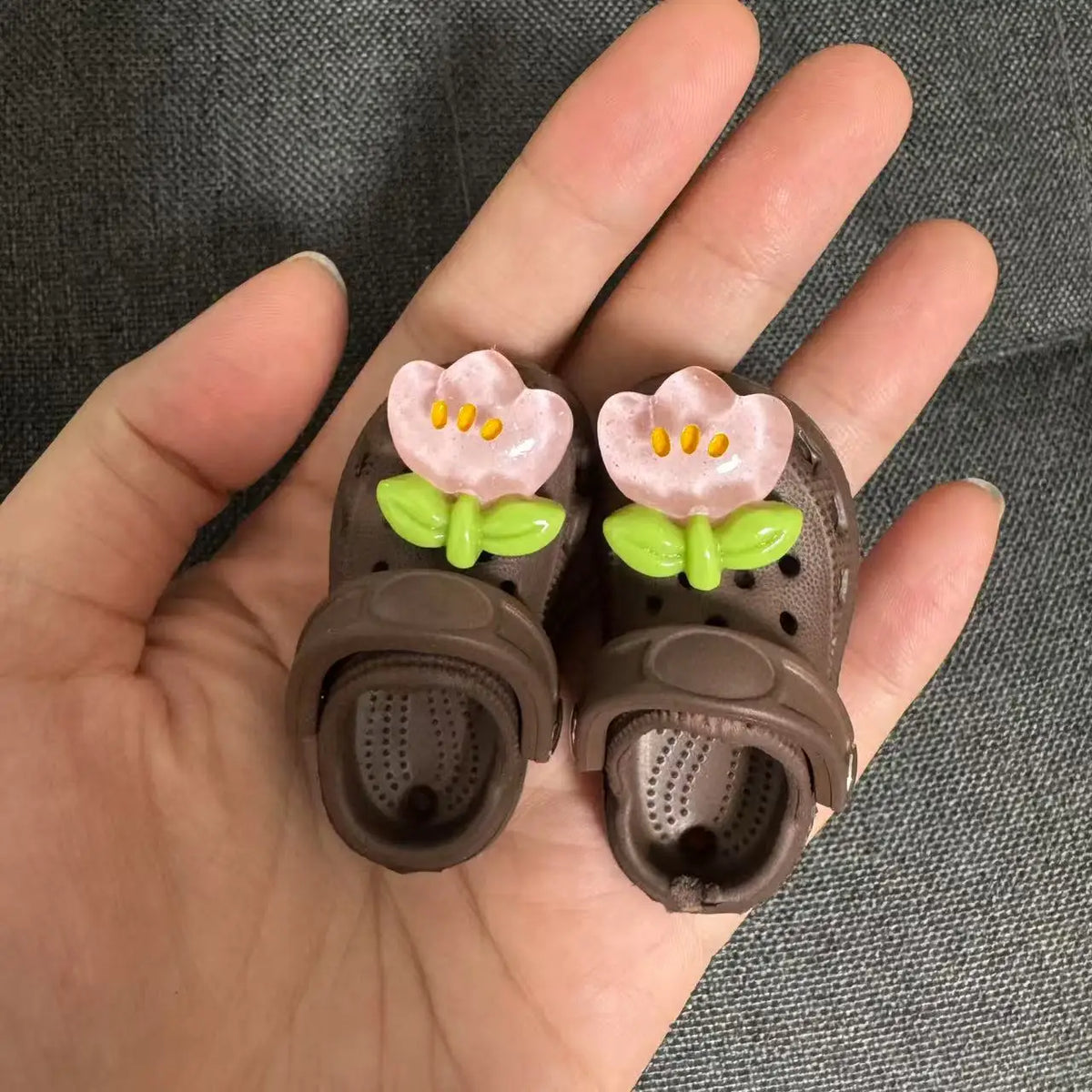 A pair of fashion slippers for 1/6 BJD dolls featuring pink flowers and green leaves.