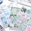 A collection of die-cut glitter stickers in blue and green shades featuring nature and cute elements for DIY crafts
