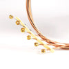 A close-up of phosphor bronze acoustic guitar strings with anti-rust coating, showing the fine wires and gold-colored connect