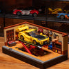 A detailed building block set depicting a retro car repair shop with yellow and red vehicles on a wooden platform.