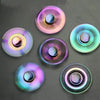 A collection of colorful metal fidget spinners showing various iridescent and holographic colors.