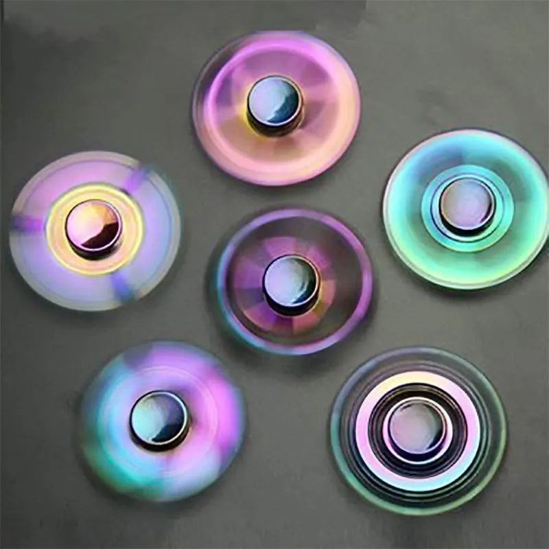 A collection of colorful metal fidget spinners showing various iridescent and holographic colors.