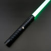 A white and green lightsaber toy with a black metal handle is shown against a dark background.