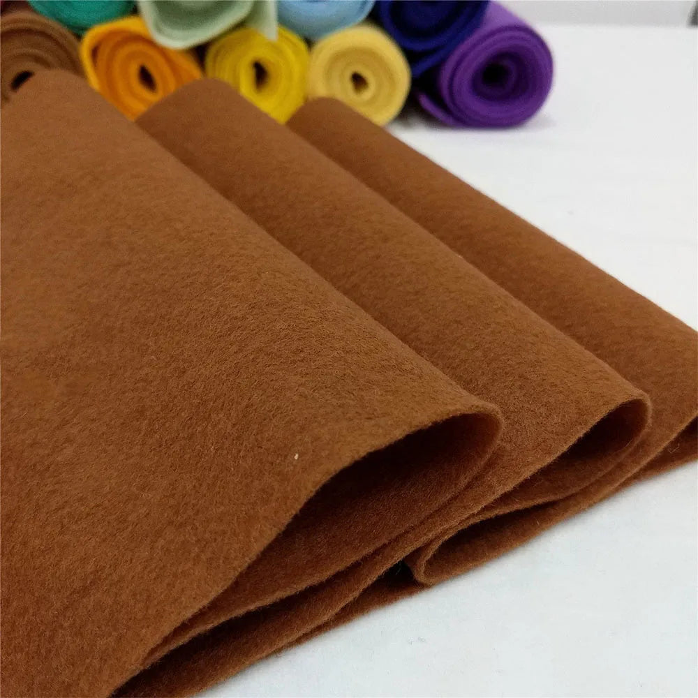A stack of brown felt fabric sheets rolled up, showing various shades and textures.