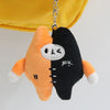 An orange and black plush pendant doll featuring a face cutout and stitched details.