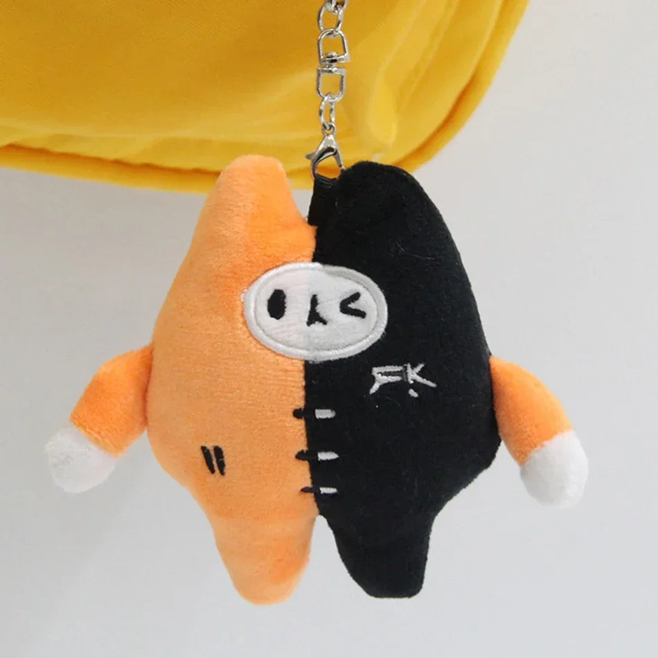 An orange and black plush pendant doll featuring a face cutout and stitched details.