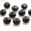 A collection of black, round crystal glass beads used for jewelry making.