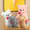 A collection of plush teddy bears in white, pink, and gray colors sitting on a wooden surface.