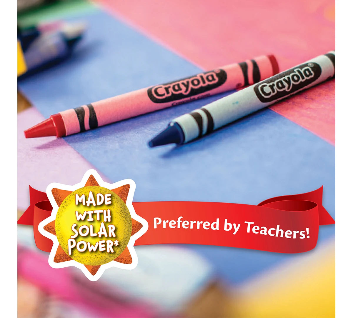 A set of Crayola colored pencils lying on a blue surface with a red ribbon and text indicating they are preferred by teachers